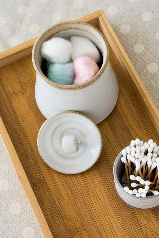 Handcrafted ceramic jar with twine accent, filled with cotton swabs 
